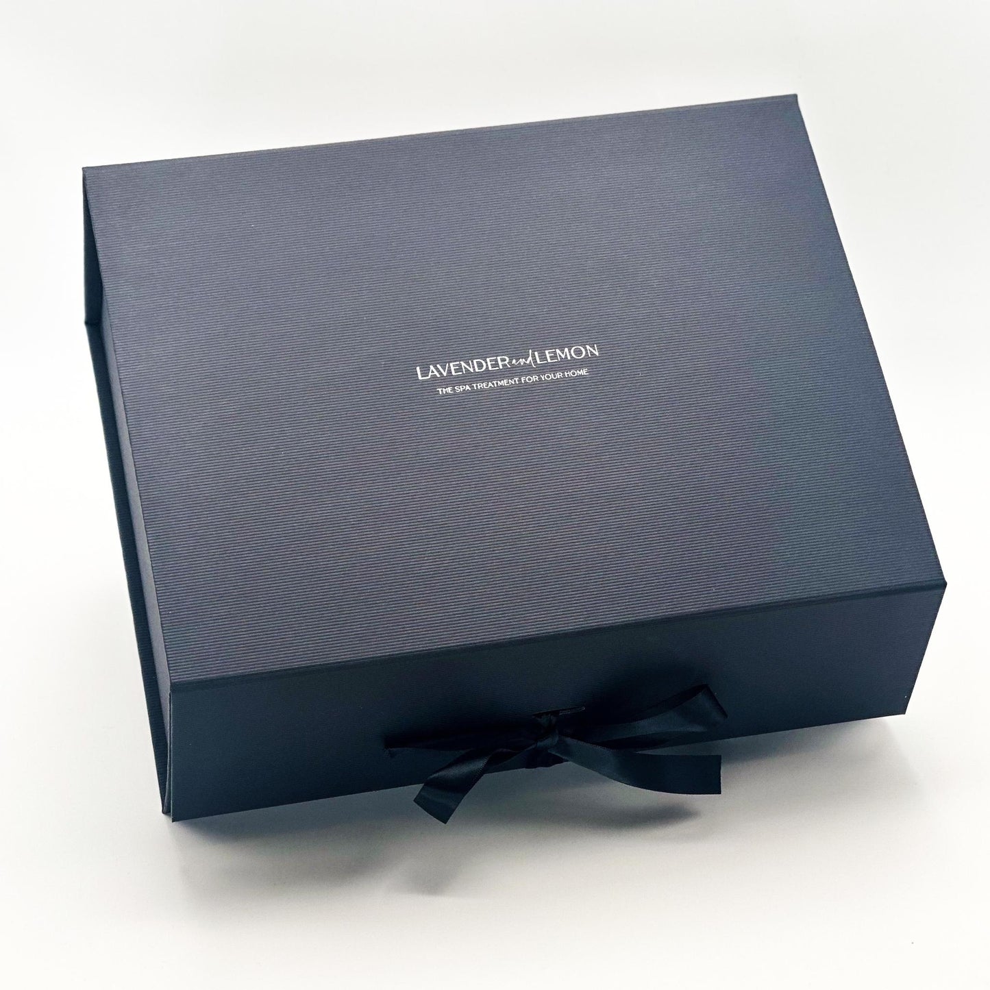 Black gift box with a black satin bow on a white background, featuring the brand 'Lavender and Lemon'.